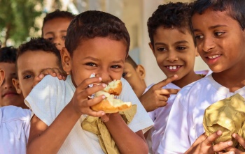 Niños en Yemen comiendo juntos en la escuela.