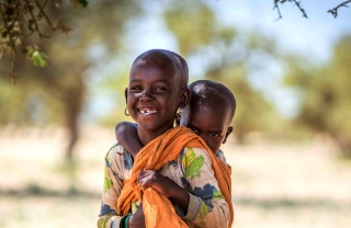 Un niño lleva a su hermano menor en su espalda en Turkana, Kenia.
