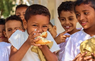 Niños en Yemen comiendo juntos en la escuela.