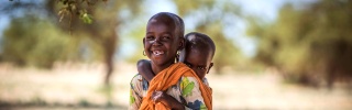 Un niño lleva a su hermano menor en su espalda en Turkana, Kenia.