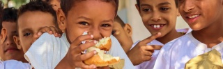 Niños en Yemen comiendo juntos en la escuela.
