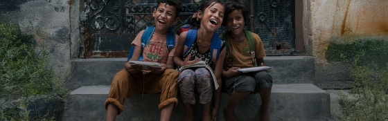 Children smiling and looking into camera.