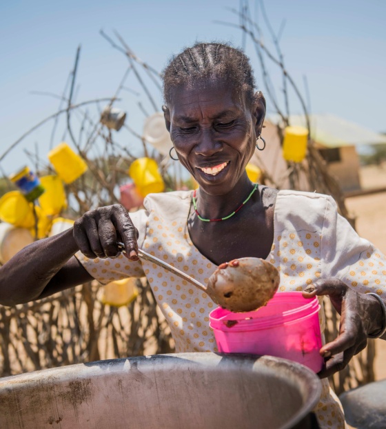 Un cocinero voluntario sirve comida desde una olla en Turkana, Kenia.