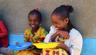 Dos niñas comparten una broma en un parque infantil en Etiopía.