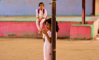 Una niña comiendo en el patio de una escuela en Yemen.