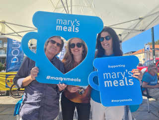Image of Mary's Meals supporters posing with Mary's Meals props.