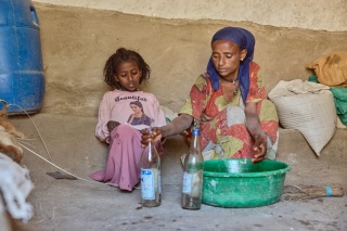 A mother and her child preparing some food.